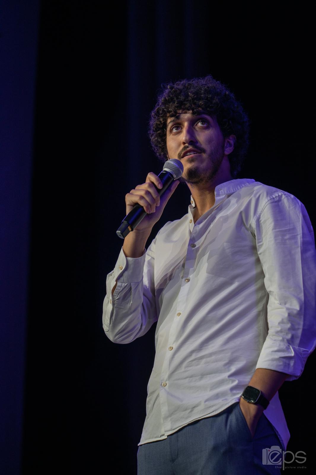 Sabri M'Barki sur scène, micro en main, lors d'un spectacle