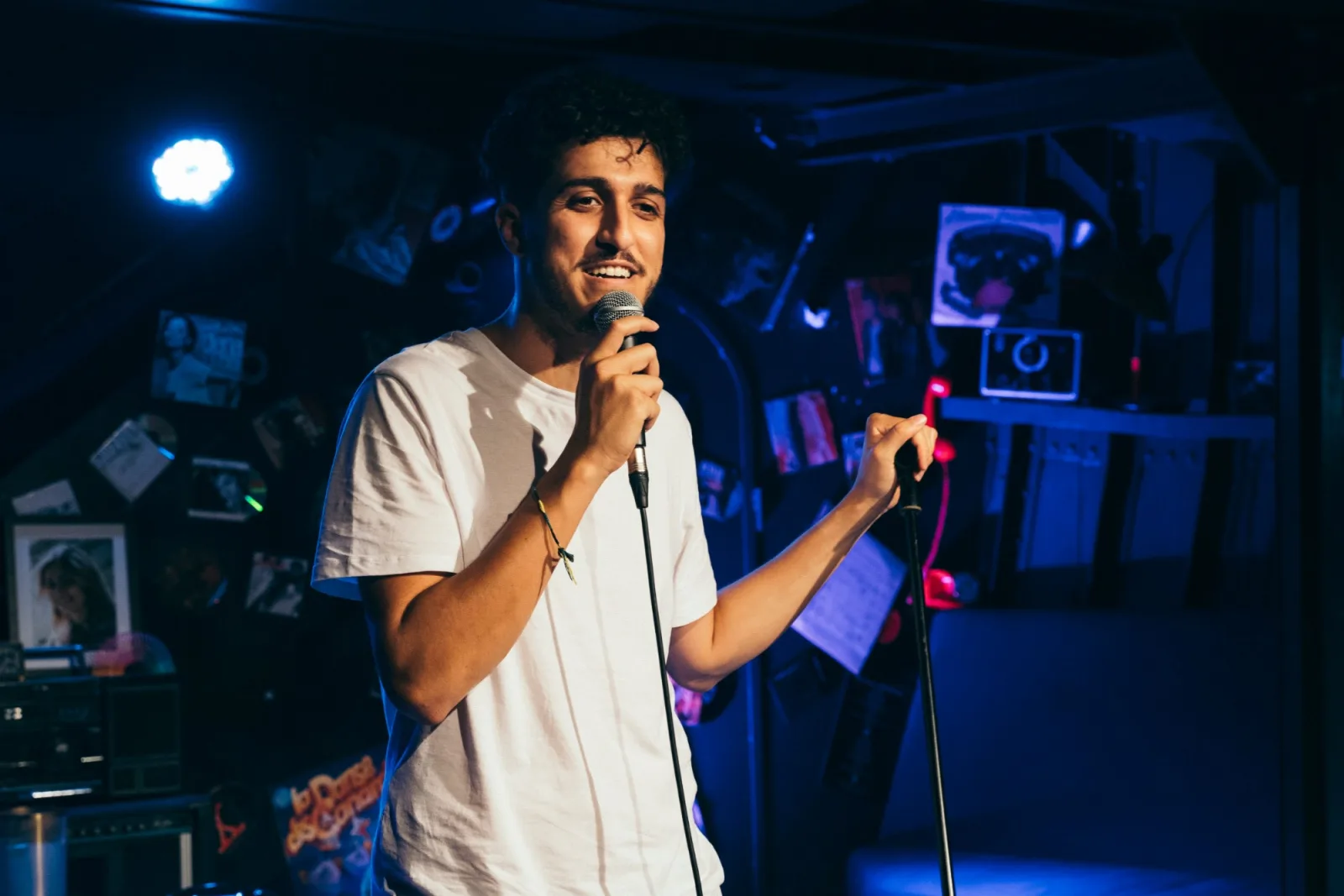 Sabri M'Barki sur scène, micro à la main, dans un comedy club